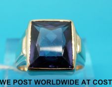 A yellow metal ring marked 14k gold set with a rectangular cut purple sapphire