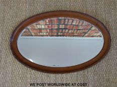 An oval mahogany bevelled glass mirror (H77 x W50cm)