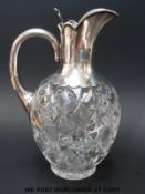 A Victorian hallmarked silver mounted and glass claret jug with hinged lid,