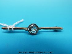 An Edwardian 15ct gold brooch set with a round cut aquamarine flanked by an old cut diamonds