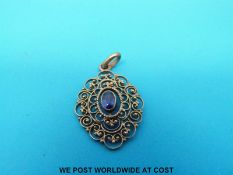 A filigree yellow metal pendant marked 333 set with a central sapphire