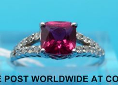 WITHDRAWN A white metal ring set with a single ruby and diamonds (size M)