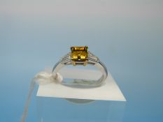 A platinum ring set with a laboratory grown square cut yellow diamond of approximately 0.