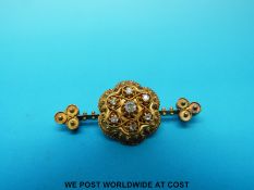 A yellow metal brooch set with seven old cut diamonds