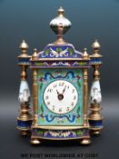 A French enamelled timepiece with pillared and finial decoration, Arabic numerals on white dial,