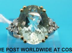 A 18ct white gold ring set with an oval aquamarine flanked by three diamonds (size N)