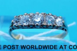 A yellow metal ring set with five diamonds in a scrolling setting (size P)
