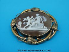 A yellow metal mounted cameo brooch decorated with a scene of a lady and cherub