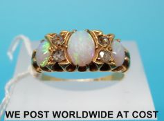 An 18ct gold ring set with three oval opals and four rose cut diamonds,