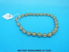 A late 19th/20th century glass bead necklace with gilt decoration.