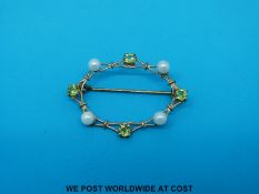 A hallmarked 9ct gold oval brooch set with pearls and peridot
