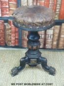 A Victorian ebonised adjustable piano stool in the manner of Shoolbred with carved and turned