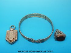 A yellow metal bangle, Victorian locket with chased decoration and a hallmarked 9ct gold fob.
