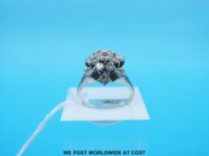 A platinum ring set with round brilliant cut diamonds in a cluster (Size O)