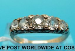 An 18ct gold ring set with five old cut diamonds in a scrolling setting (size P)