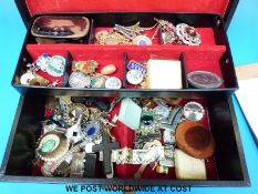 A quantity of costume jewellery to include brooches, badges, a coral bead,