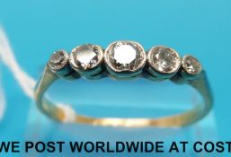 A yellow metal ring marked 18ct set with five diamonds in a platinum setting (size X)