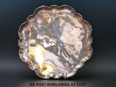 A George VI hallmarked silver salver with shaped edge and raised on four feet, Sheffield 1937,