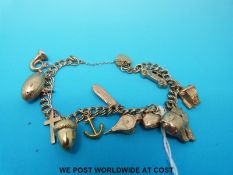A 9ct gold charm bracelet with 11 hallmarked 9ct gold charms including a fish, rugby ball,
