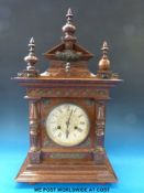 A continental two train clock with oak case, metal mask decoration,