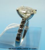 A platinum ring set with a round brilliant cut diamond measuring approximately 4.