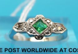 A white metal ring marked 18ct set with an emerald and diamonds (size I)