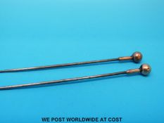 A pair of yellow metal topped hat pins