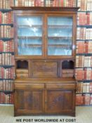 An Edwardian secretaire bookcase with glazed top and fall front flanked by cubby holes and two