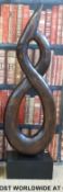 A large hardwood carving/sculpture mounted on an ebonised wooden plinth (H108 x W40 x D18cm)