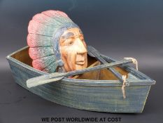 A novelty three division treen rowing boat with oars and a carved native American Indian bust