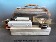 A leather doctor's bag containing various instruments including scalpels Lewis Bros London,