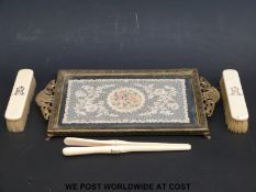 Three ivory backed dressing table items and a gilt tray inset with lace.