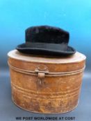 A vintage Homburg hat in a metal hat box