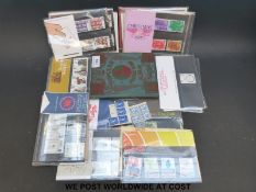 Approximately 32 early GB presentation packs and a small stamp album