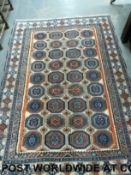 A Turkoman wool rug with a central array of 36 guls on a predominately blue ground