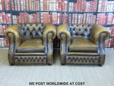 A pair of leather Chesterfield club armchairs with button backs and metal stud decoration,