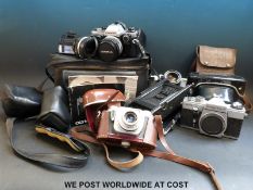 A collection of cameras including an Olympus CM10 with spare lens,