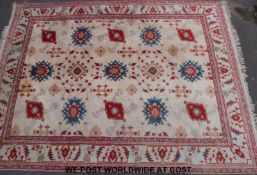 A large wool rug with red, blue and green pattern on cream ground,