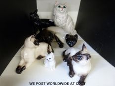 Six Royal Doulton and Beswick cats including a rarer black gloss example