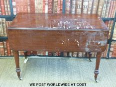 A mahogany drop leaf table raised on ceramic castors (H72 x W106 x D107cm)