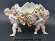 A large Dresden style jardiniere with cherubs supporting a large rose-covered bowl (24cm tall)