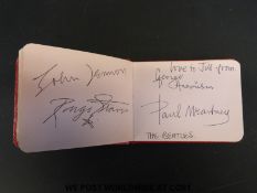 An autograph album with signatures including a page titled The Beatles.