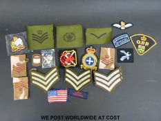 A selection of cloth military badges including sergeant's stripes etc
