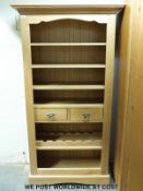 A modern light oak bookcase unit with two drawers to centre and wine rack below (W90 x D40 x