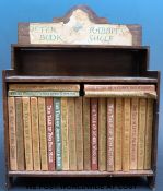A collection of Beatrix Potter titles together with a Peter Rabbit bookshelf