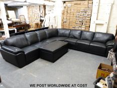 A black leather corner sofa and matching ottoman (approximately 320 x 320cm)