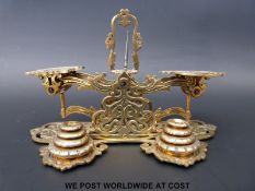 A set of pierced and cast brass postage scales with two stacks of weights to front