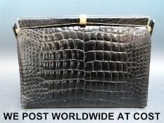 A black Vogini crocodile effect handbag with gold clasp and sides