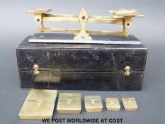 A set of travelling leather cased set of postage scales having rectangular flat weights