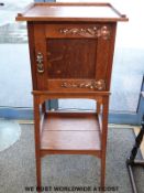 An Arts and Crafts oak cabinet on stand with copper decoration together with an oak side table with